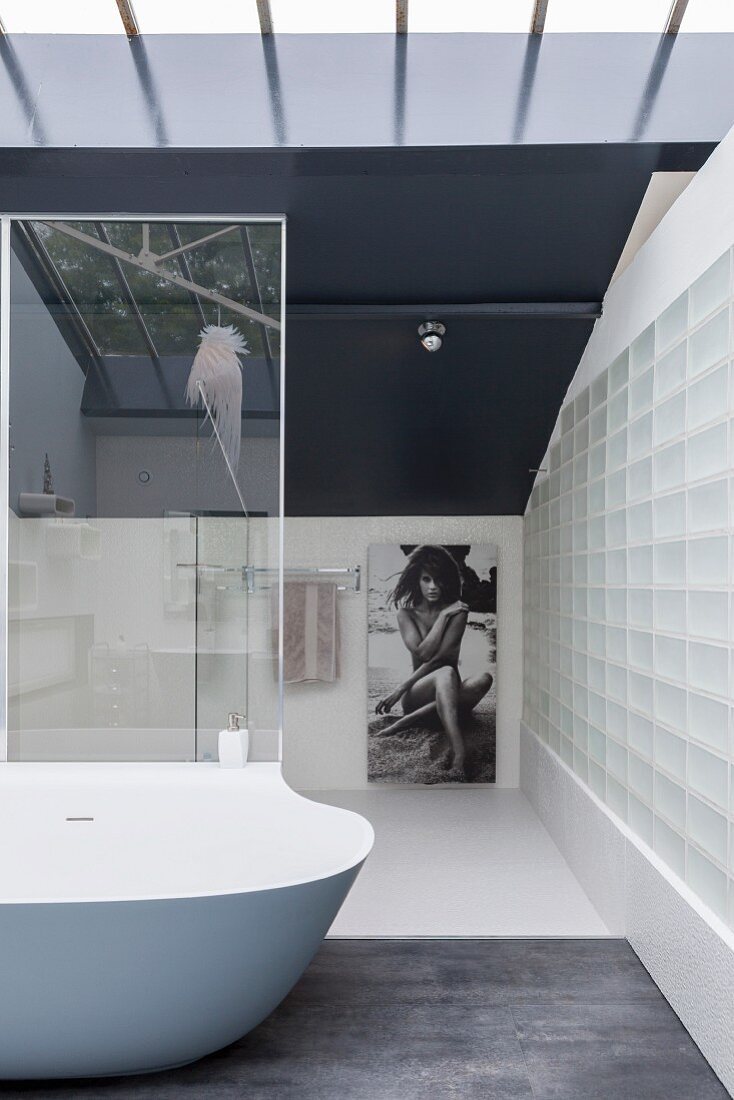 Elegantes minimalistisches Badezimmer mit Glasbausteinwand und Designerwanne