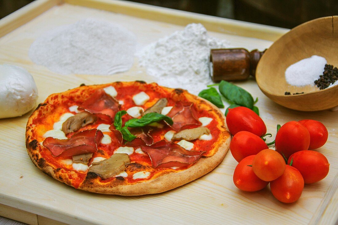 Pizza mit Bresaola, Pilzen, Tomaten und Mozzarella (Italien)
