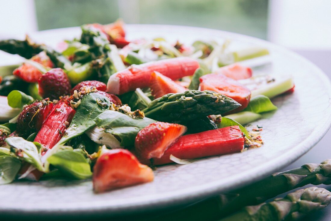 Spring salad with strawberries, surimi, green asparagus and cucumber