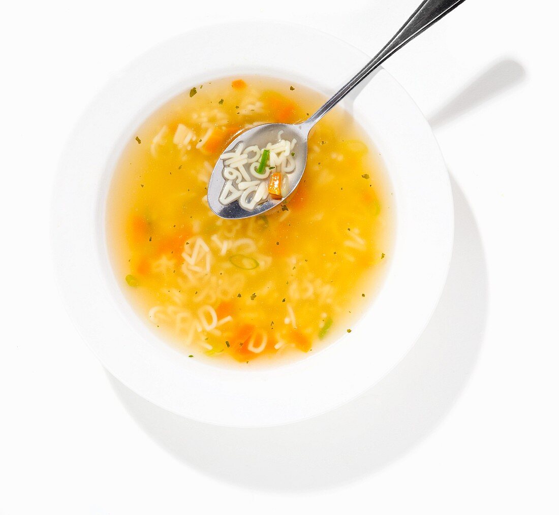 Alphabet soup in a bowl with a spoon