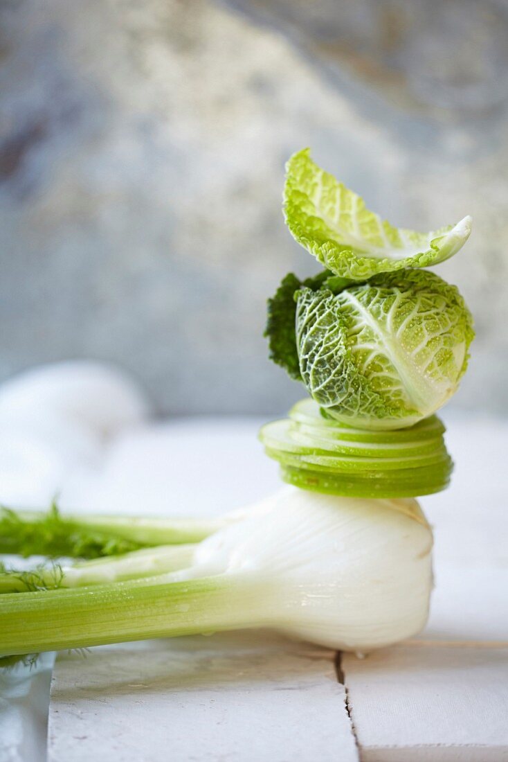 A fennel bulb, an apple and a savoy cabbage, stacked