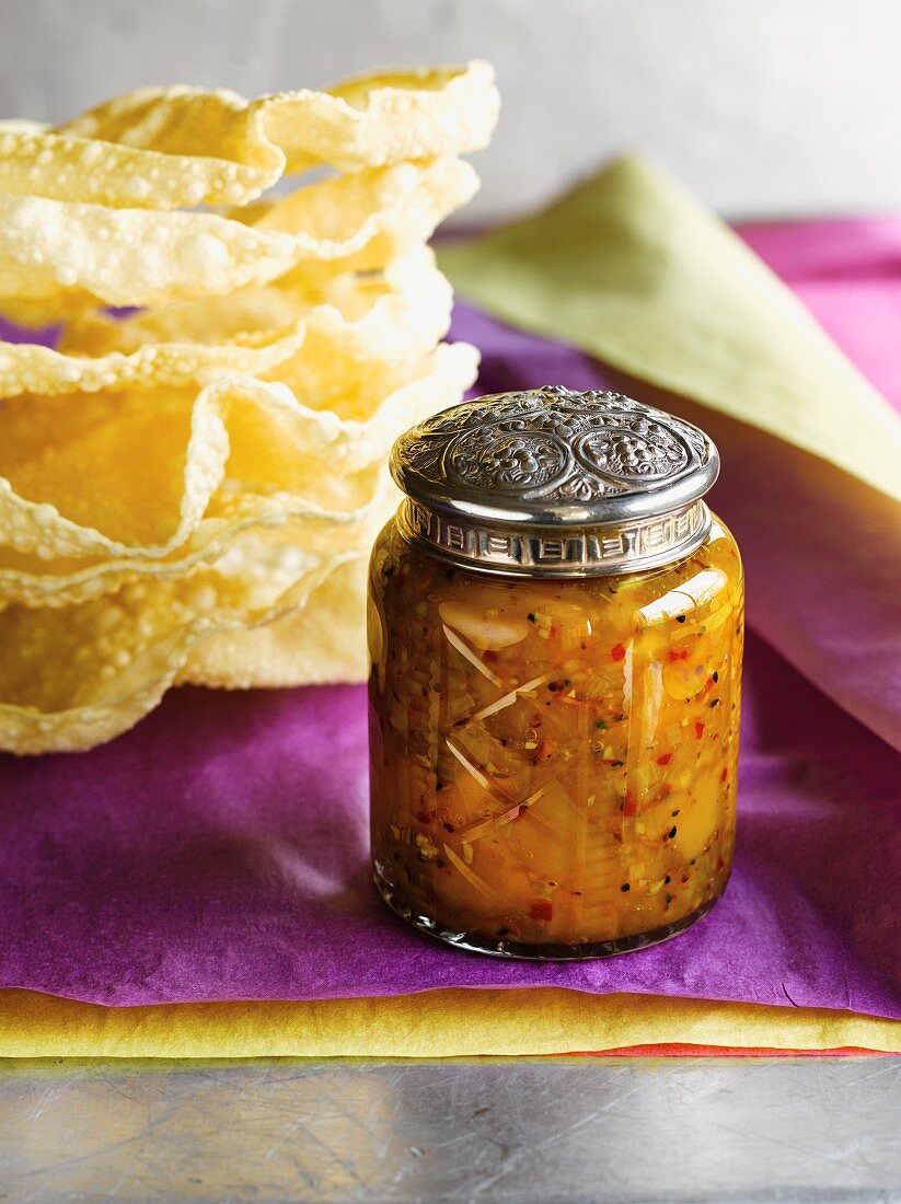 A jar of homemade chutney with a decorative metal lid