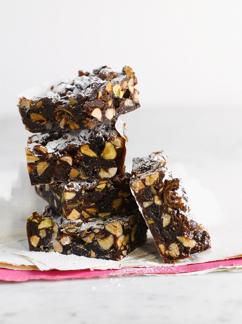 A stack of brownies with nuts and pistachios