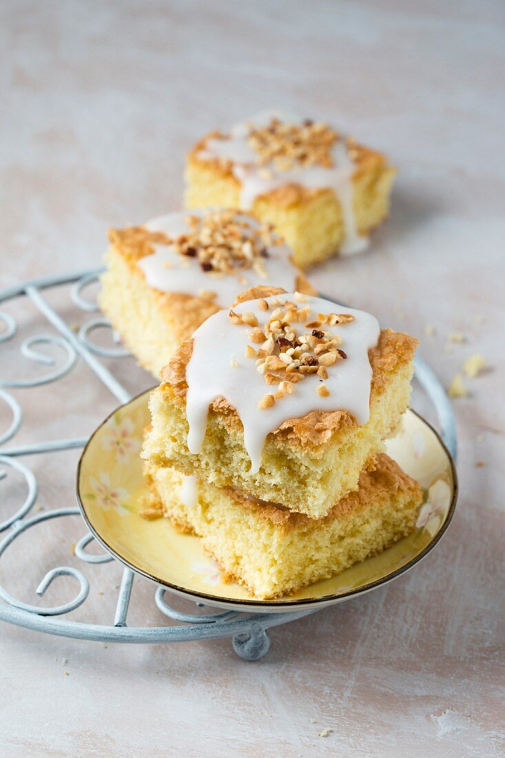 Slices of vanilla cake with icing and hazelnuts