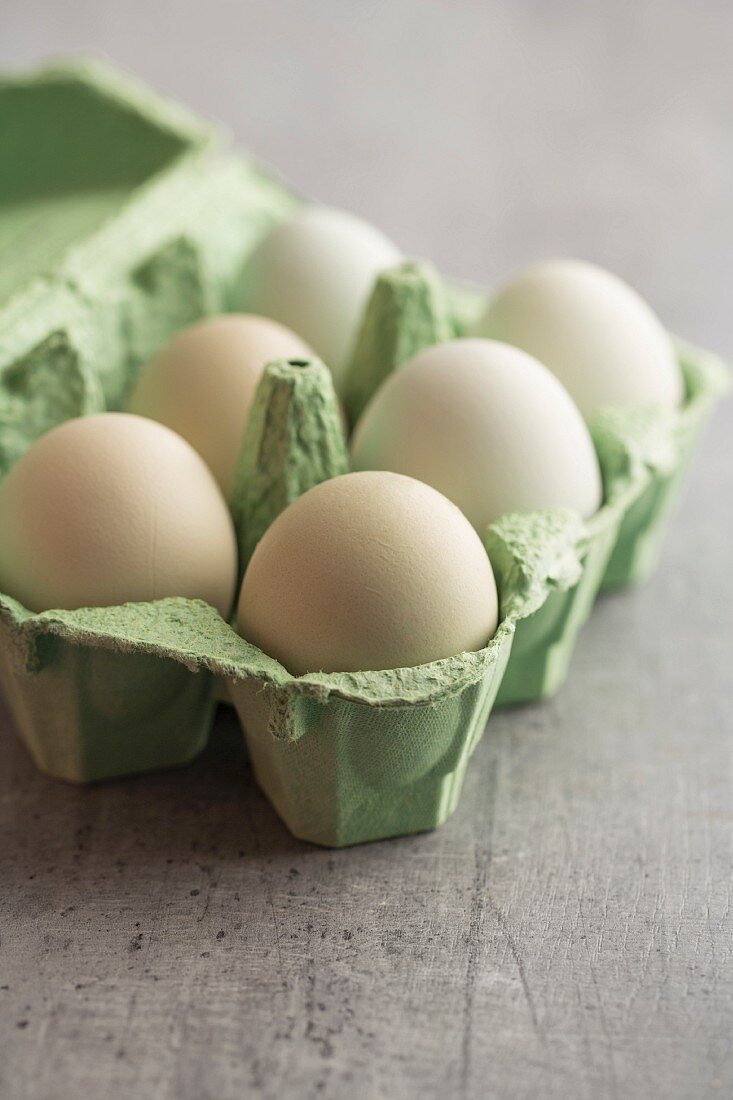 Hen's eggs with green shells in an egg box