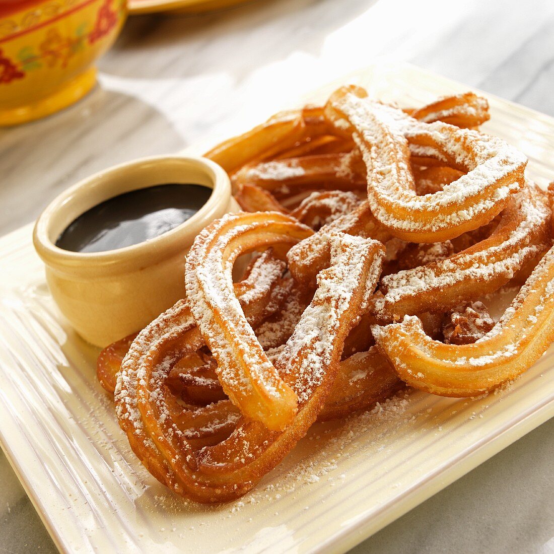 Churros with icing sugar and dark chocolate sauce (Mexico)