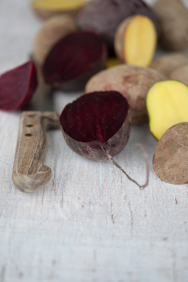 Halved beetroots and potatoes with a knife