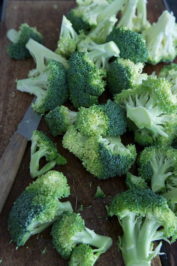 Broccoli with a knife on a chopping board