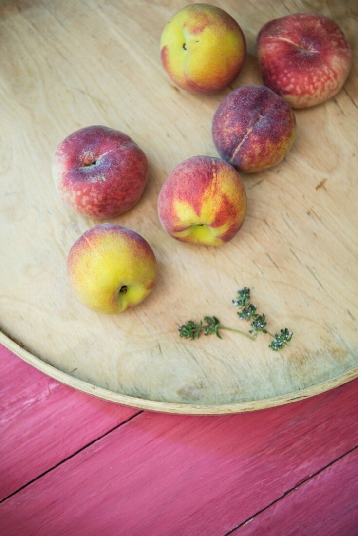 Peaches and thyme on a wooden surface