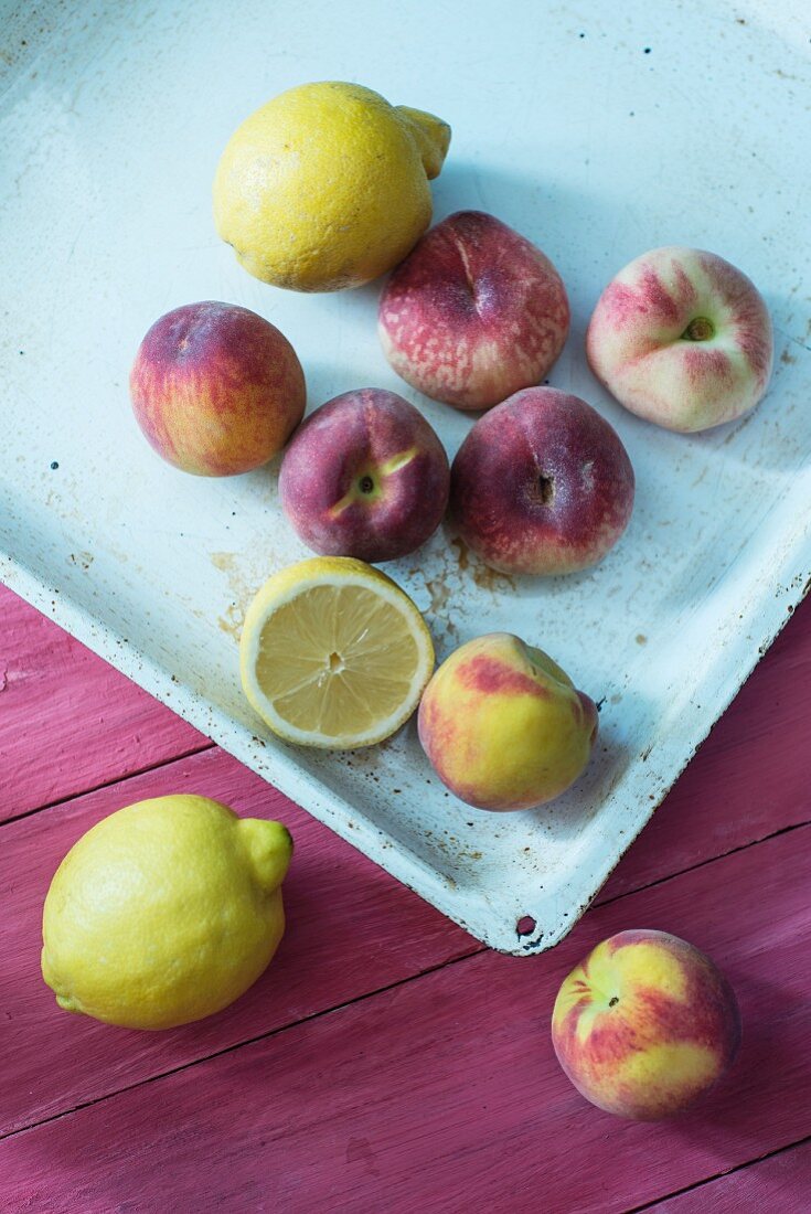 Pfirsiche, Weinbergpfirsiche und Zitronen auf Backblech