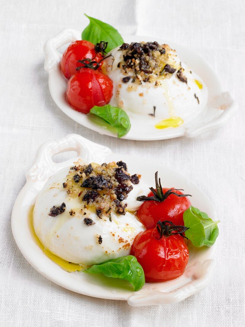 Baked mozzarella with olive crumbs, tomatoes and basil