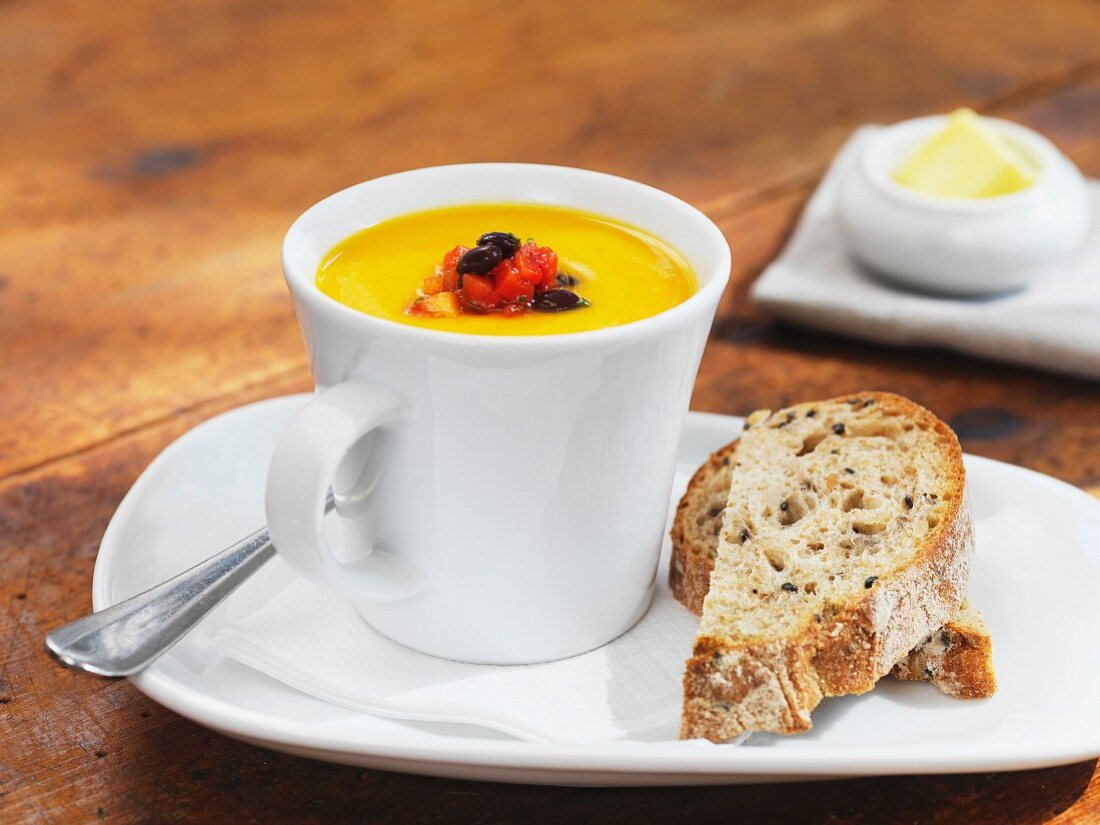 Cream of pumpkin soup in a cup with bread