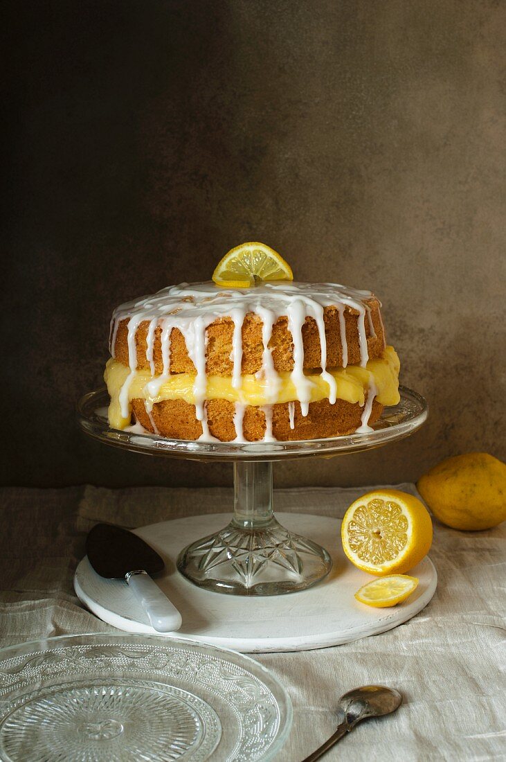 Sponge cake with lemon curd and lemon icing on a cake stand