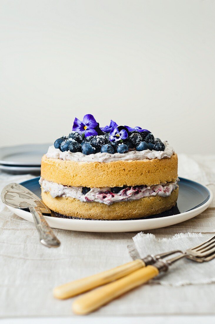 Blueberry cake with mascarpone and blueberry cream and pansies