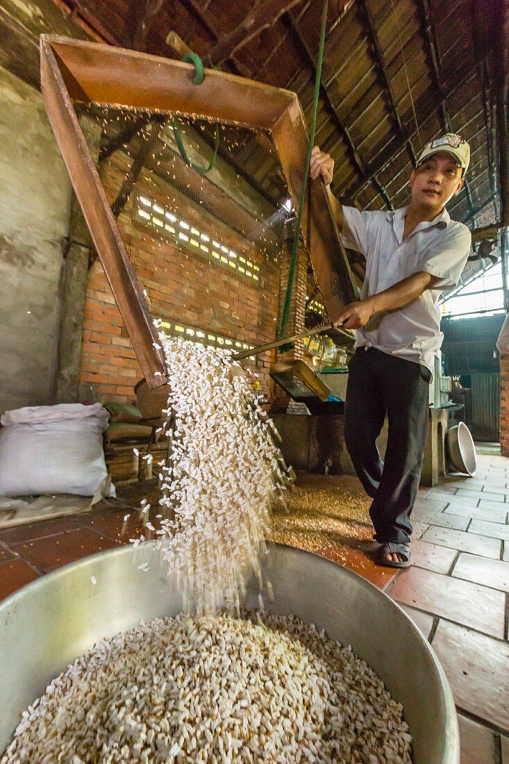 Mann stellt Süssigkeiten aus Palmzucker und Reis her (Cai Be, Vietnam, Indochina, Südostasien)