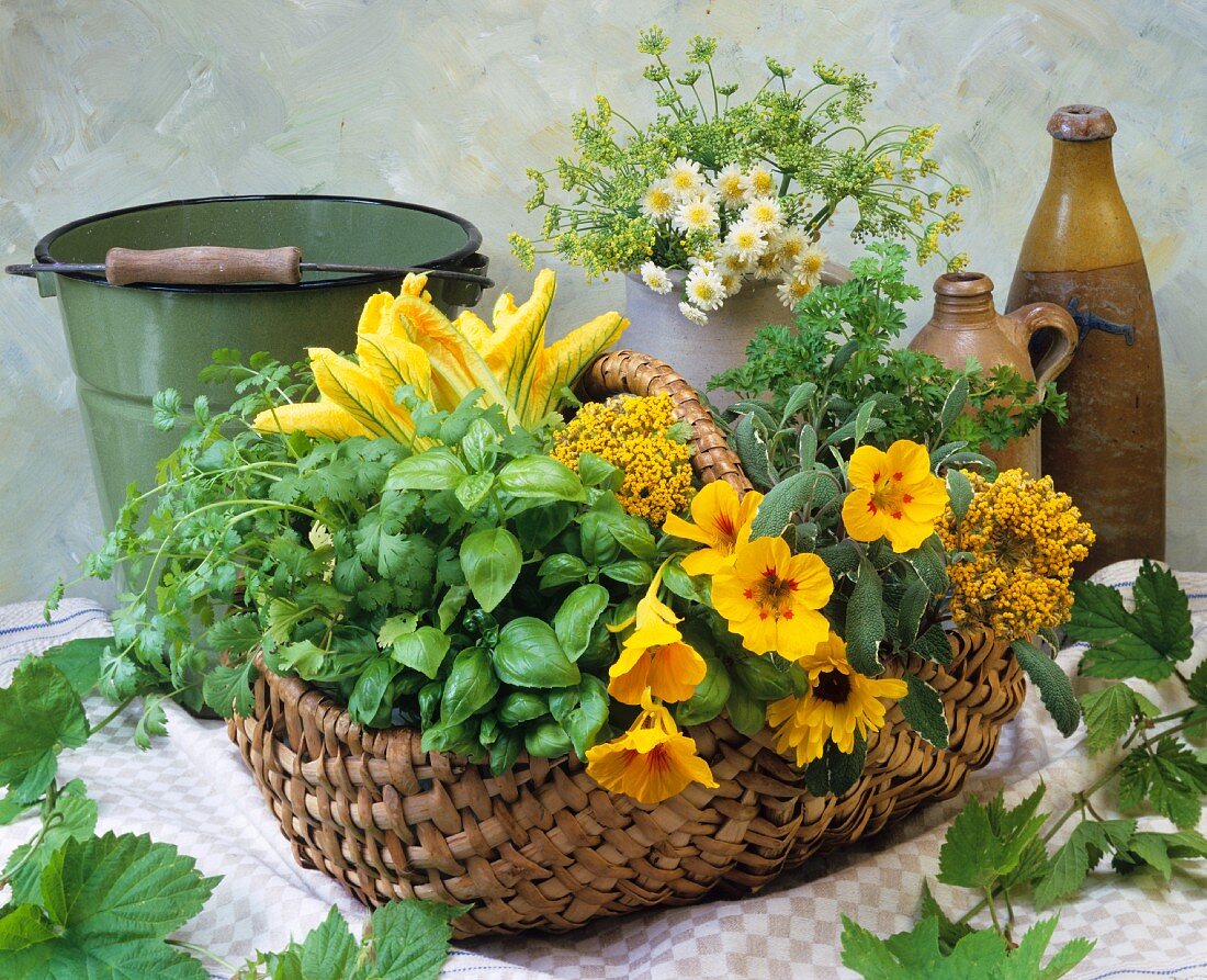 An arrangement of fresh herbs and edible flowers in a wicker basket