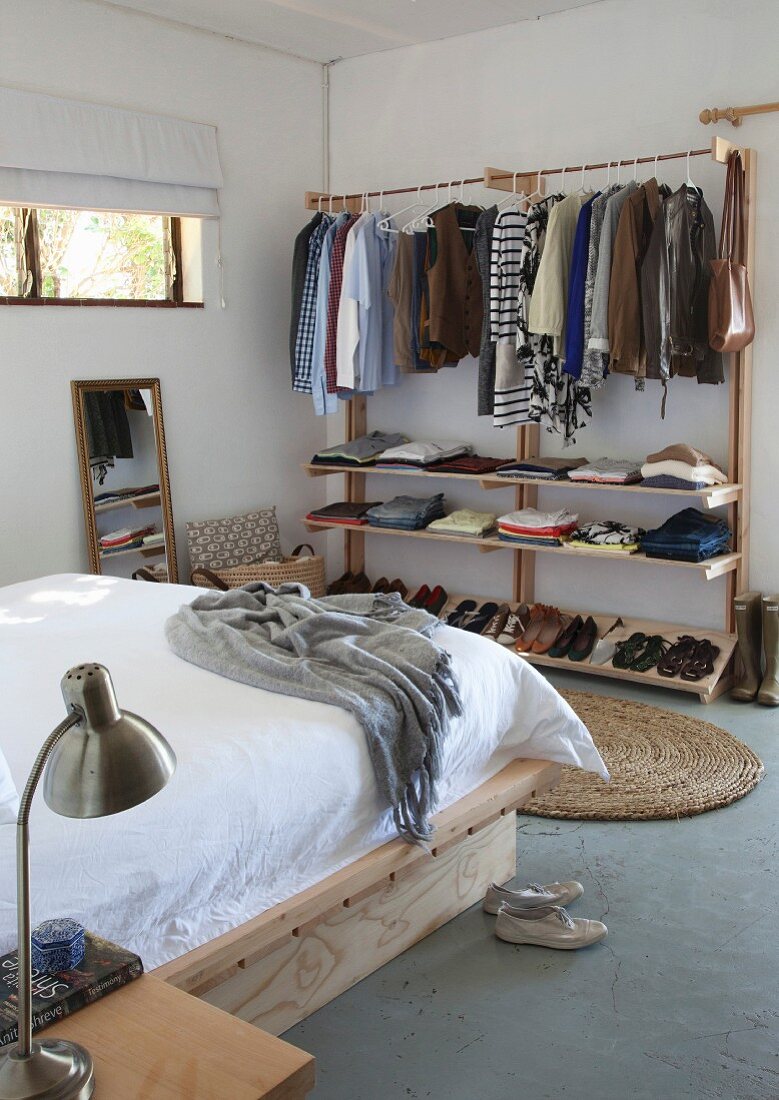 Clothes rails with shelves in simple bedroom