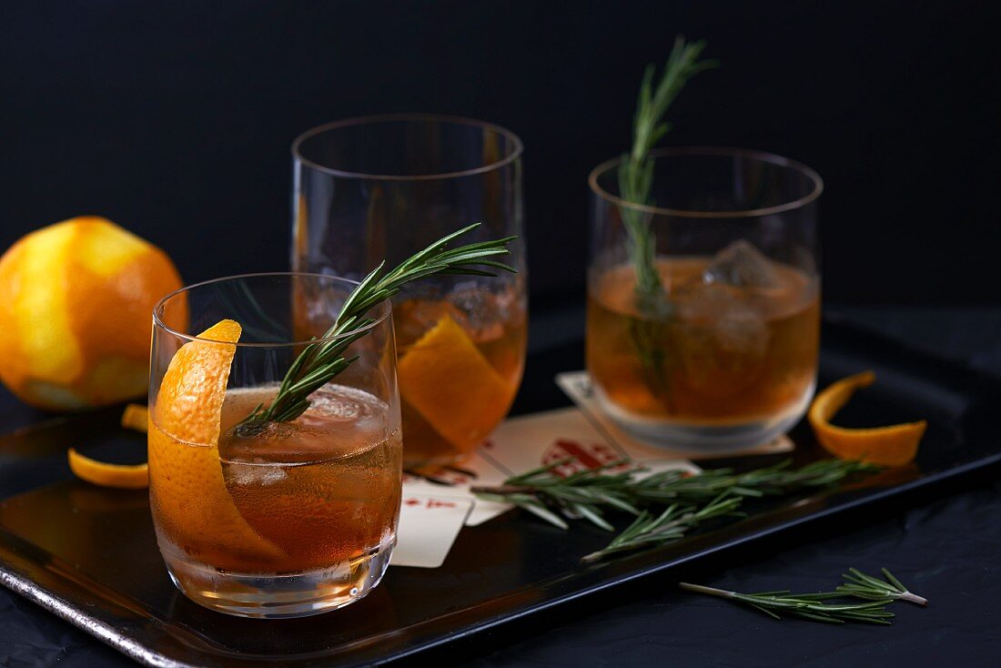 Old Fashioned cocktails with orange peel and rosemary