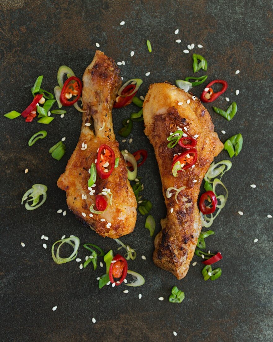 Spicy chicken drumsticks with chilli rings and spring onions