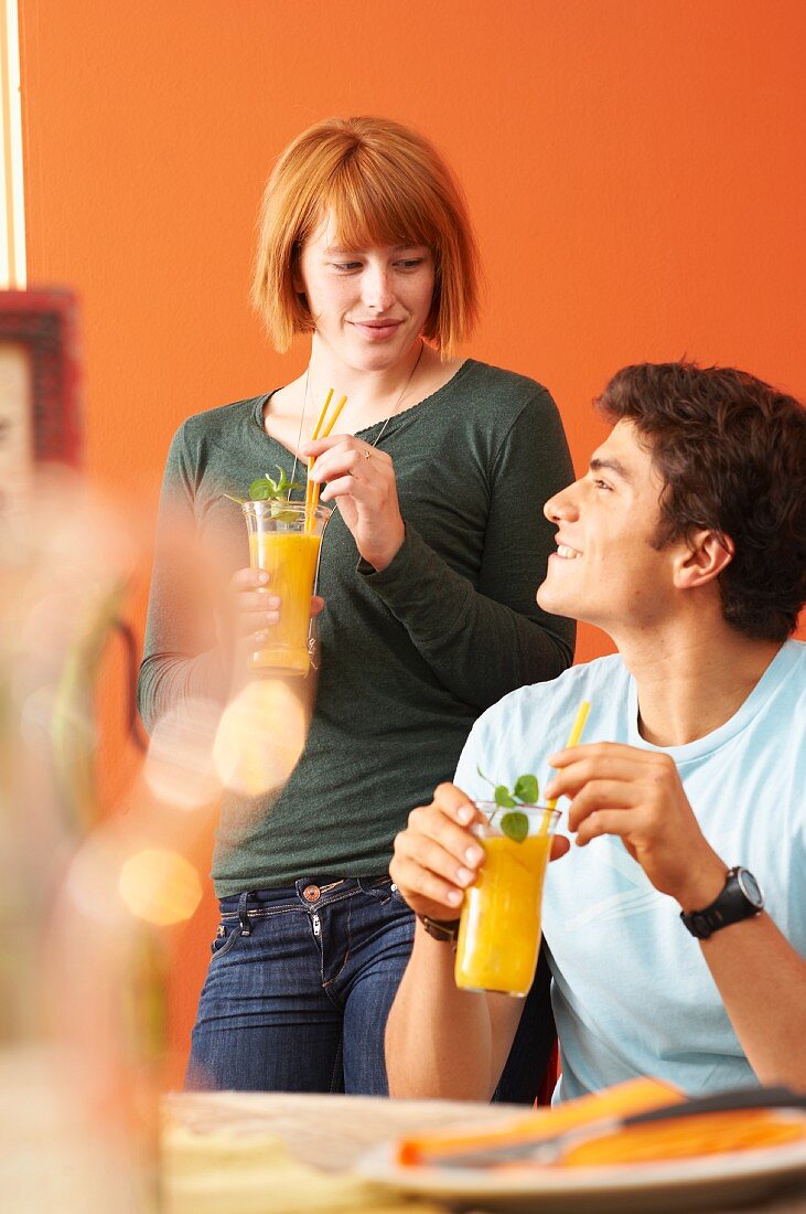 A young couple with mango mojitos