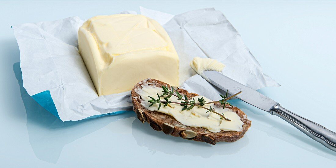 A slice of bread spread with butter and thyme