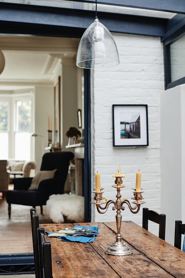 Silver candelabra on wooden table in front of doorway leading into living room