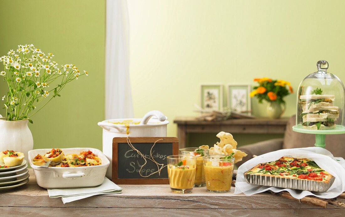 Sommerliches Buffet mit verschiedenen Gerichten und beschrifteter Schiefertafel