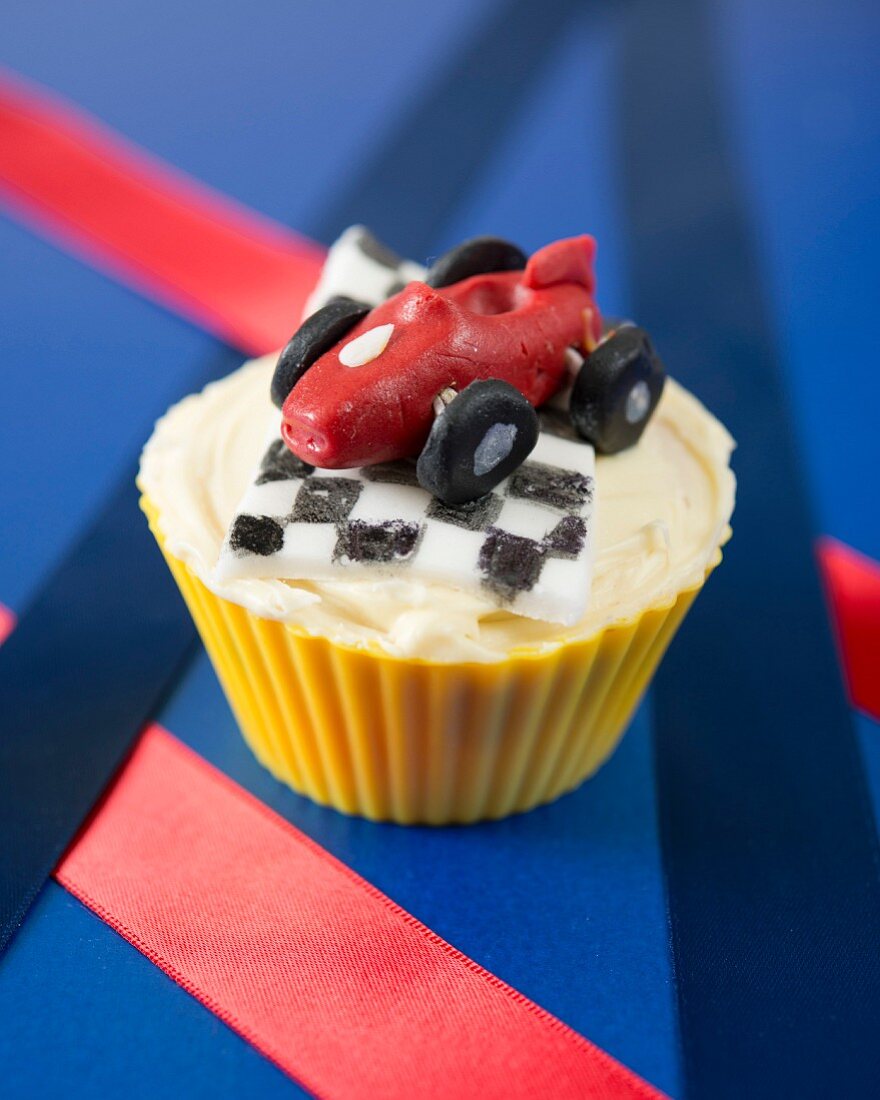 A racing car cupcake with a checked flag