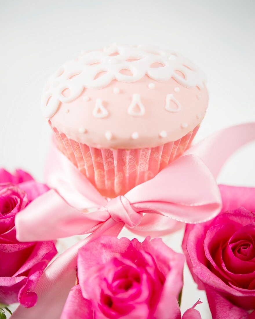A pink cupcake with sugar decorations