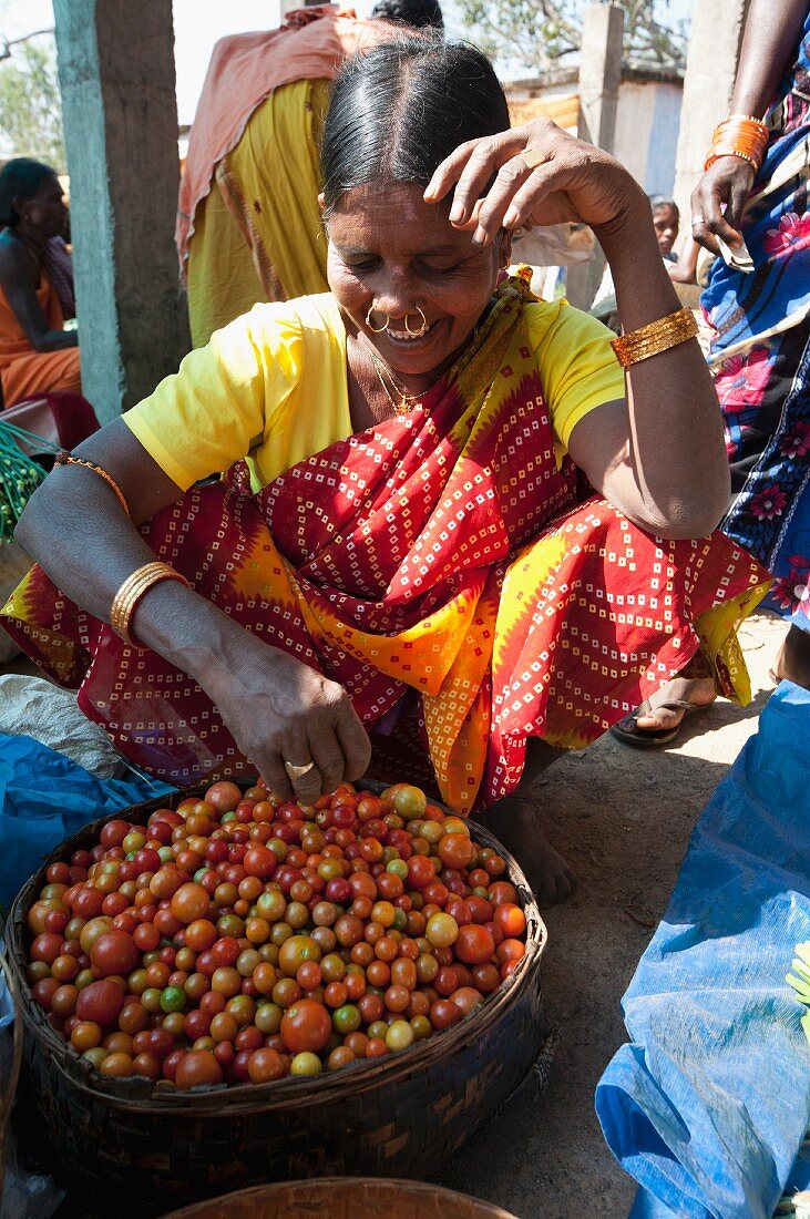 Stammesangehörige der Mali mit Goldnasenringen beim Tomatenverkauf auf einem Wochenmarkt in Guneipada, Koraput Bezirk, Orissa, Indien
