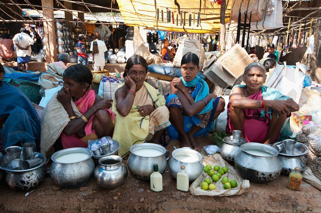 Mali-Frauen mit Goldnasenringen beim Verkauf von Joghurt aus Metalltöpfen auf einem Wochenmarkt, Guneipada, Orissa, Indien