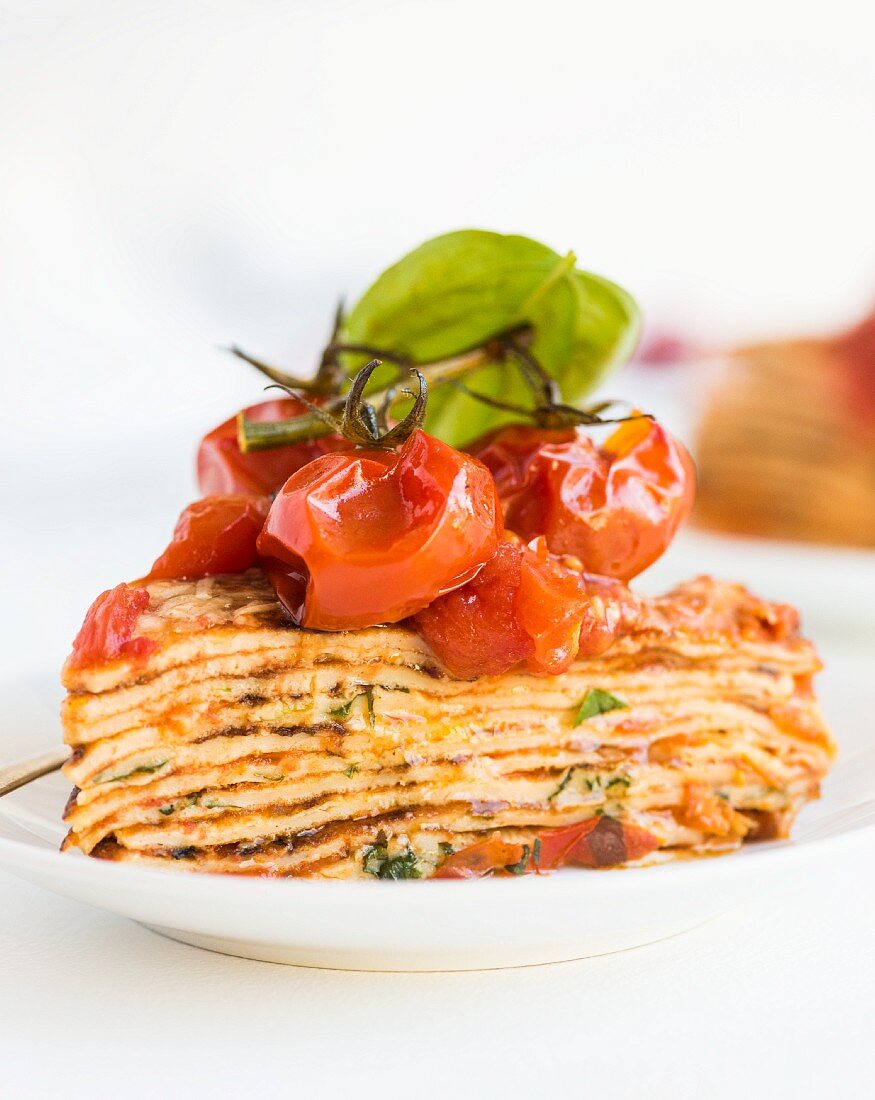 A slice of pancake cake with tomatoes