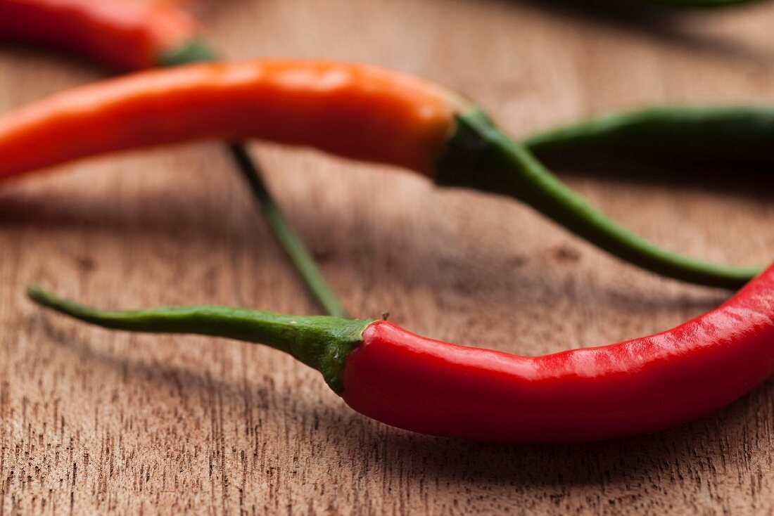 Mehrere frische rote Chilischoten auf Holzuntergrund