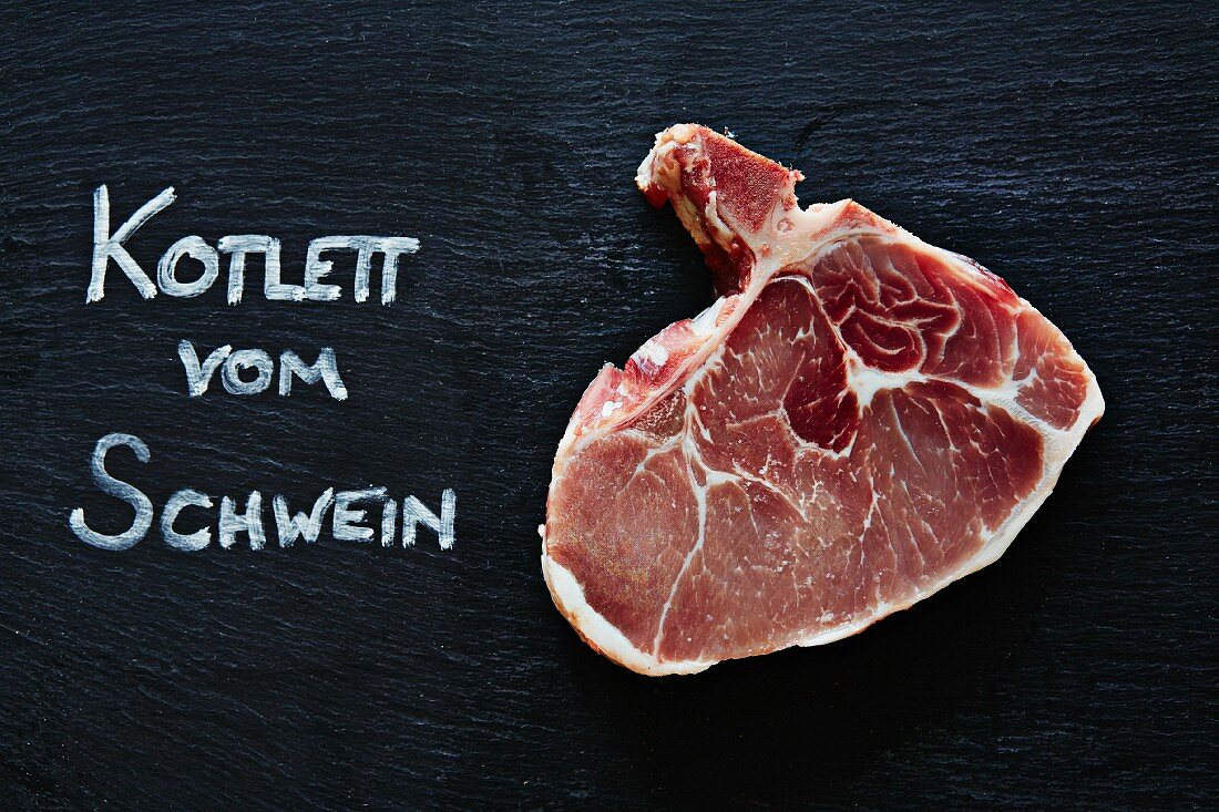 A raw pork chop with German writting