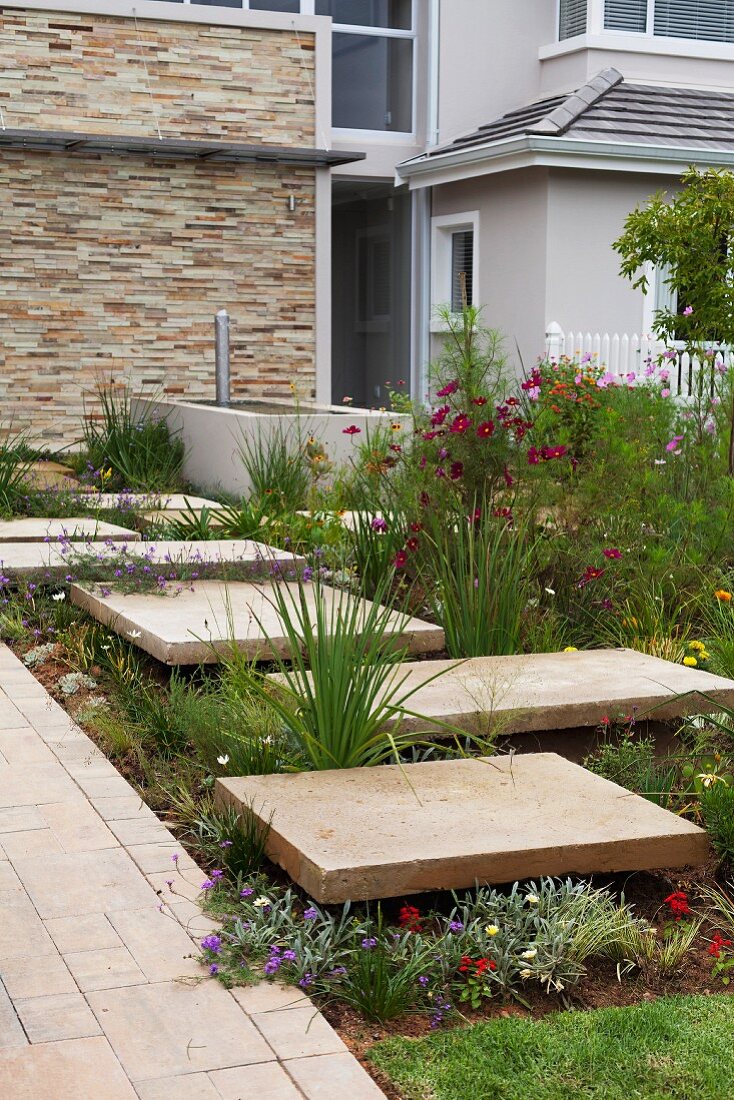 Detail of garden; stepping stones in flower bed next to path