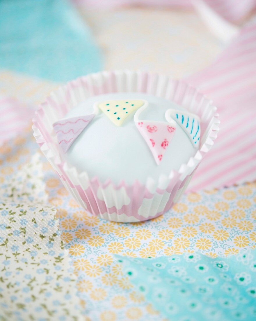 A cupcake decorated with fondant bunting