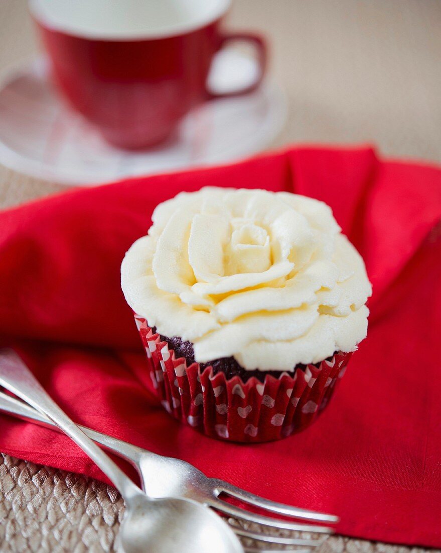 A cupcake decorated with a white chocolate rose