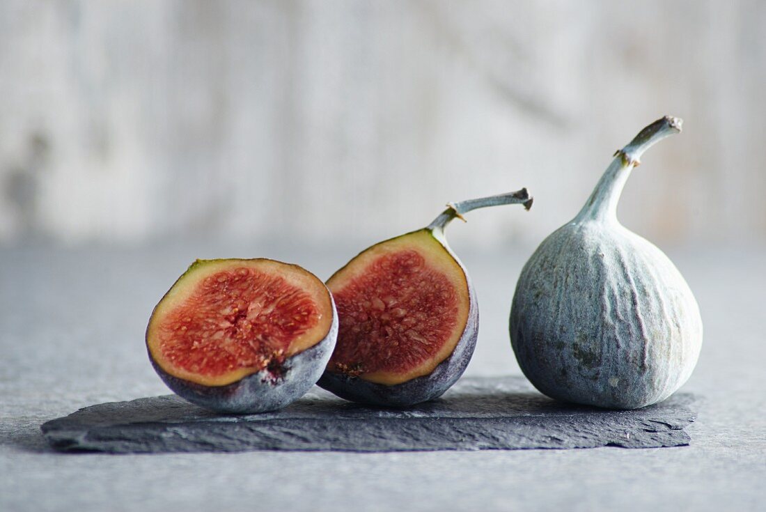 Figs, whole and halved, on a piece of slate