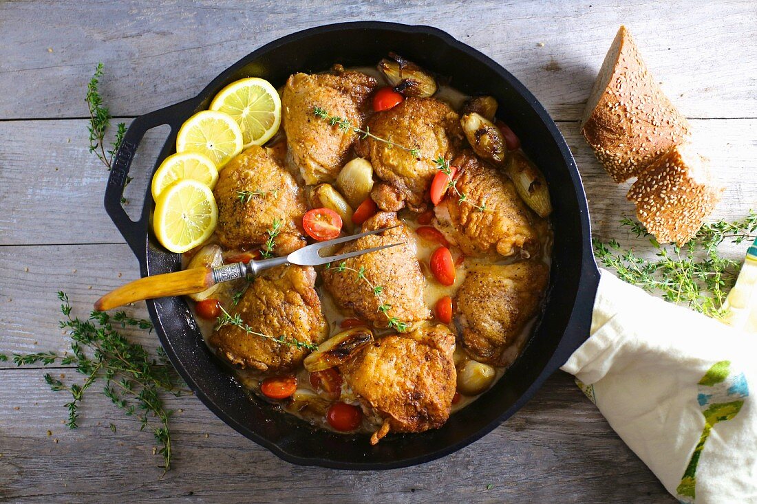 Chicken thighs with lemons, garlic and tomatoes (seen from above)