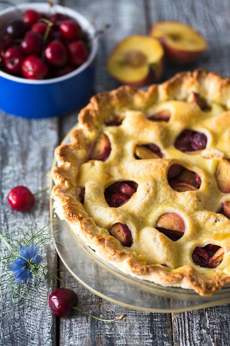 Cherry pie with peaches and a decorative pastry topping