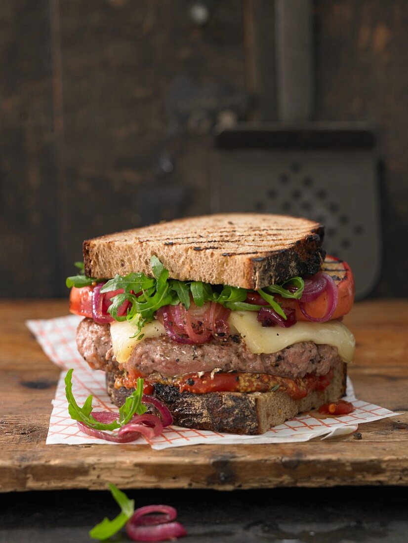 A brown bread burger with mountain cheese, minced lamb, grilled apple and sweet and sour onions