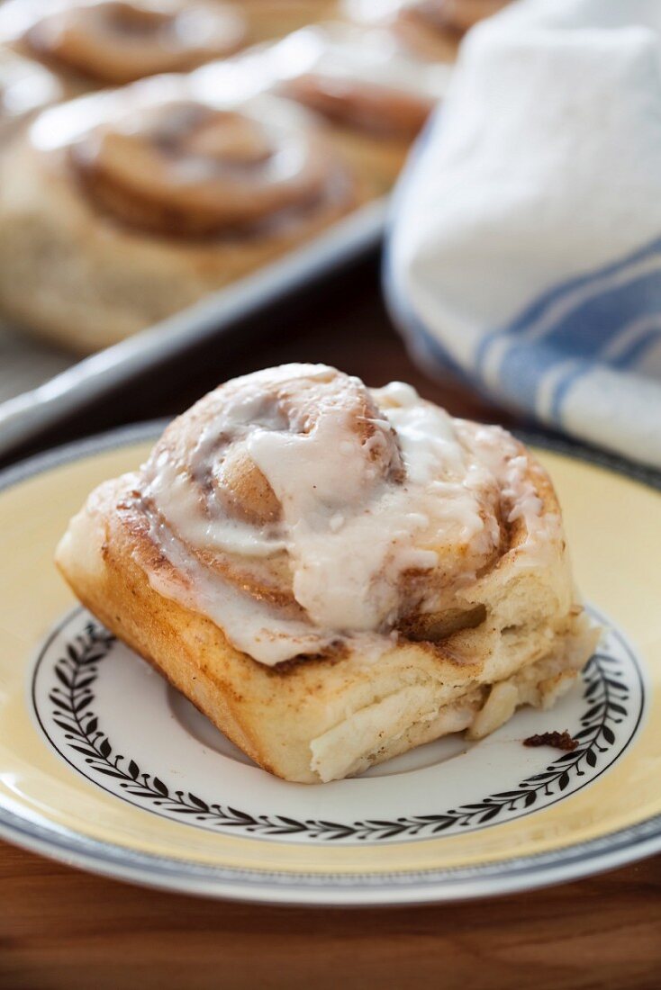 A cinnamon bun with pecan nuts and butter glaze