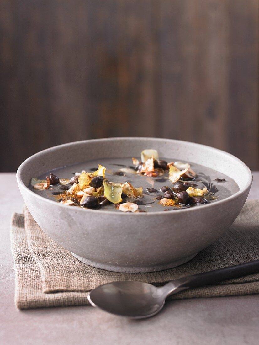 Chickpea soup with black chickpeas, fried white cabbage and roasted hazelnuts