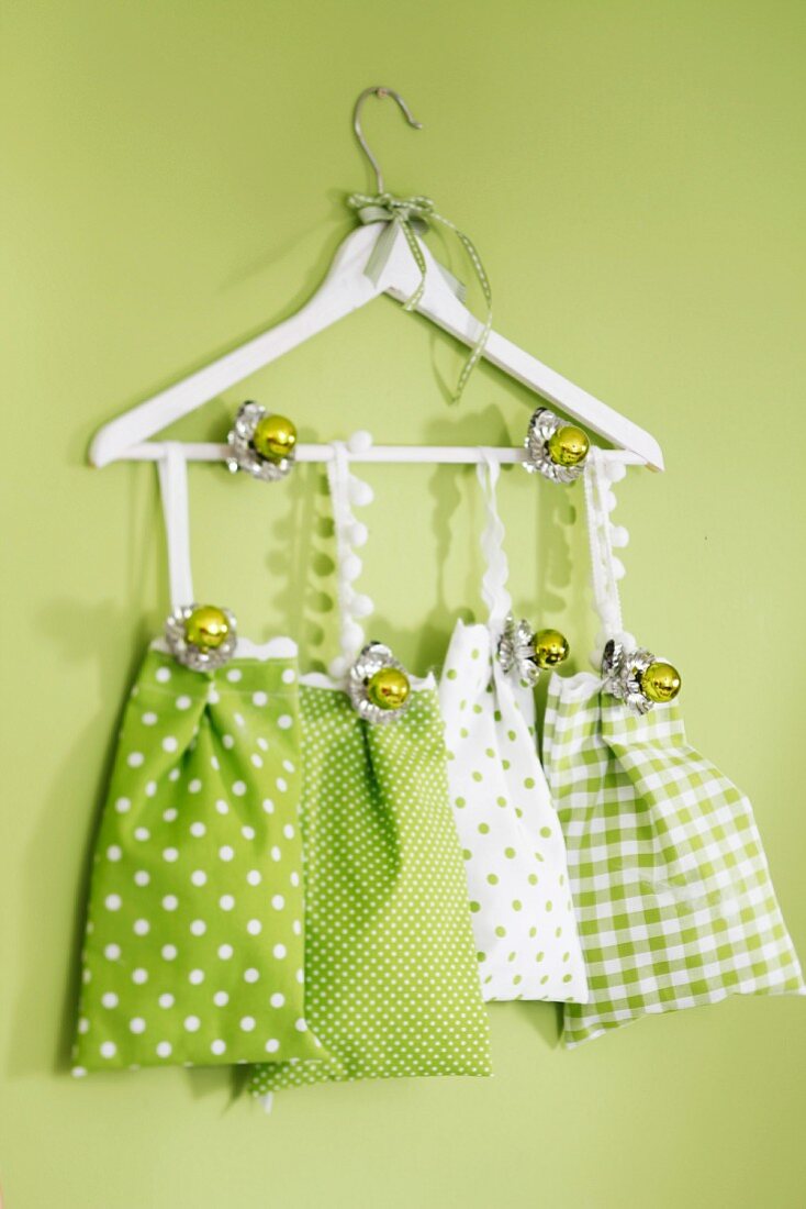 Fabric bags in shades of green hanging from clothes hanger