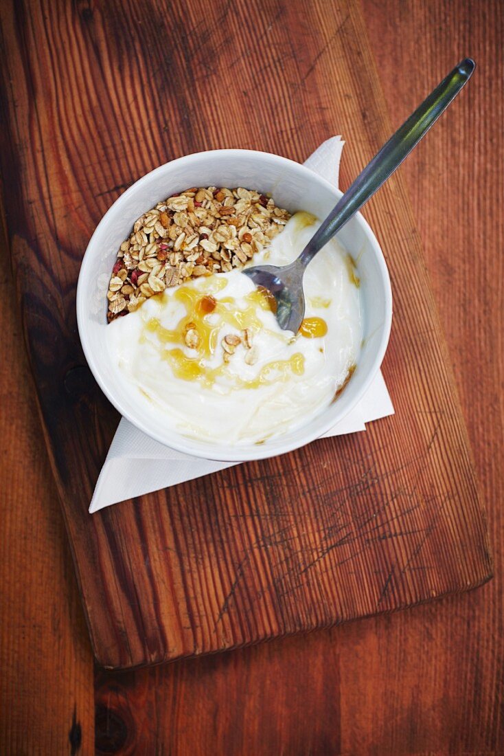 A bowl of muesli with yoghurt and honey (seen from above)