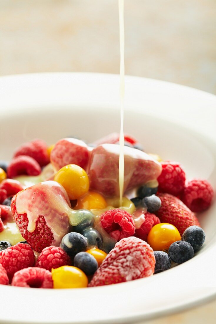 Vanilla sauce being poured over fruit