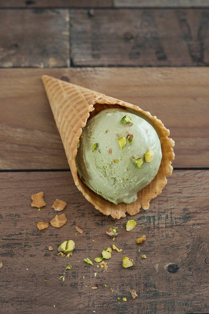 A scoop of pistachio mascarpone ice cream in a cone