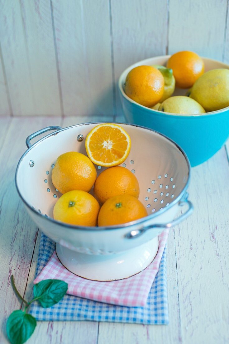 Orangen im Emaillesieb, Orangen und Zitronen in Porzellanschüssel, frische Minze