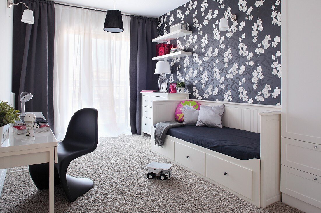 Black and white child's bedroom with floral wallpaper and classic chair