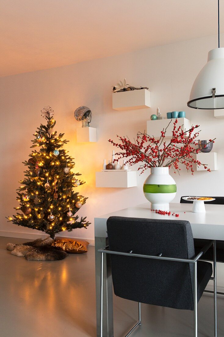 Essplatz mit Polsterstuhl, im Hintergrund leuchtender Weihnachtsbaum in modernem Ambiente